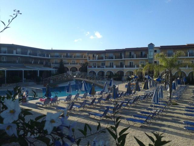 a group of chairs and umbrellas on a beach at Majestic Hotel & Spa in Laganas