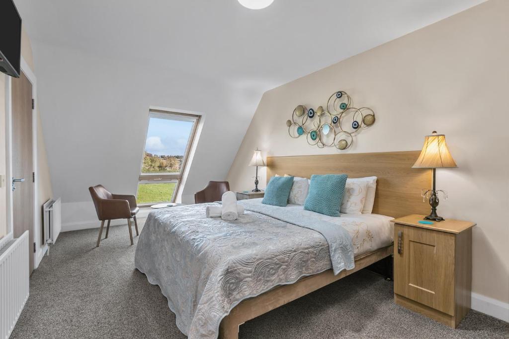 a bedroom with a large bed with blue pillows at Tollyrose Country House in Newcastle