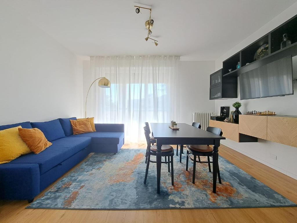 a living room with a blue couch and a table at San Paolo's Room in Milan
