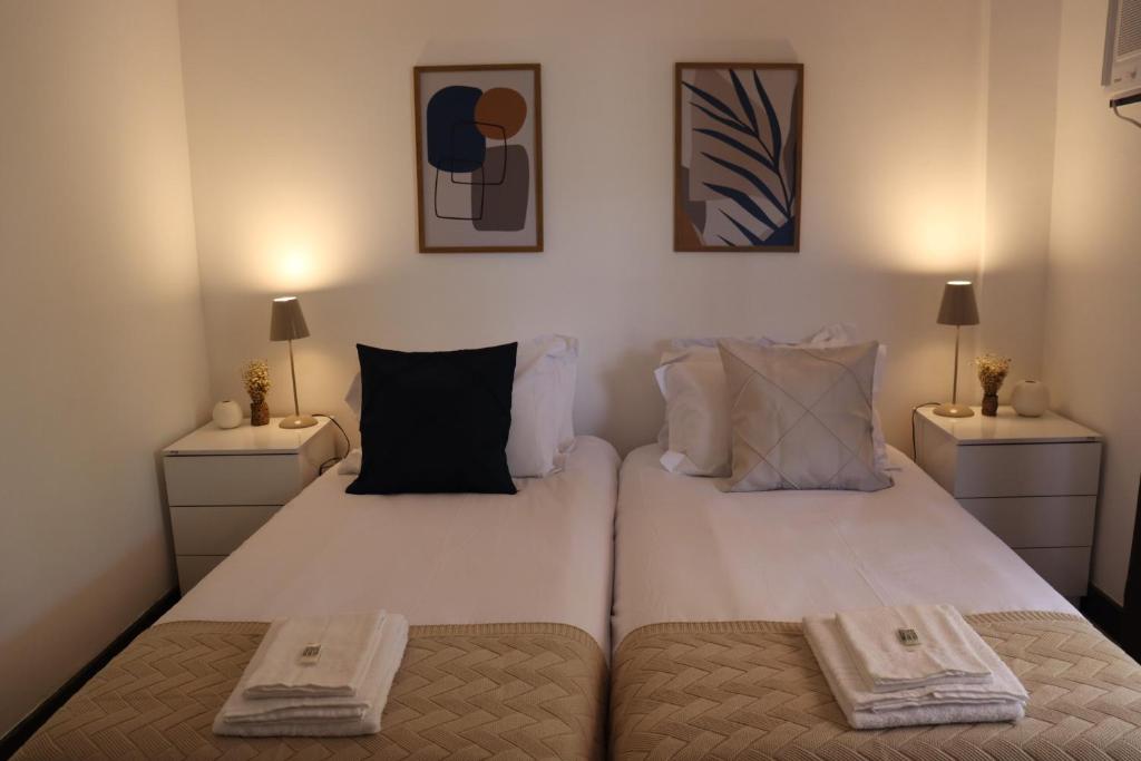 um quarto com uma grande cama branca com duas mesas de cabeceira em Local 301 Apartment no Rio de Janeiro