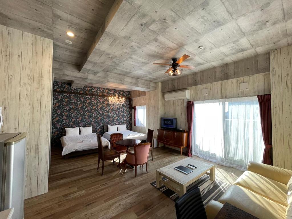 een woonkamer met 2 bedden en een tafel en een bank bij WOLF PACK apartment 1002 in Osaka