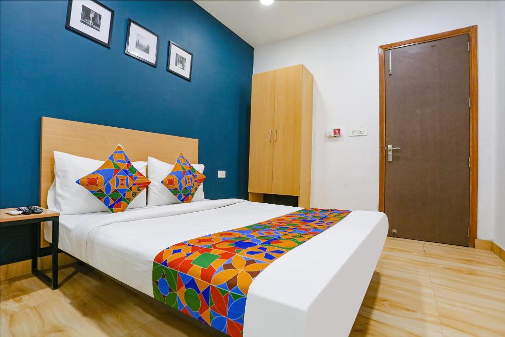 um quarto com uma cama grande e uma parede azul em FabHotel F9 Peeragarhi em Nova Deli