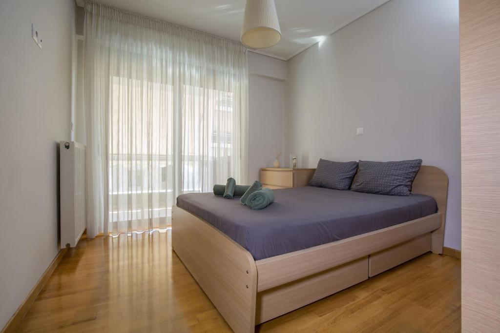 a bedroom with a bed and a large window at Lovely New Βuild Flat Near Metro - Free Parking in Athens