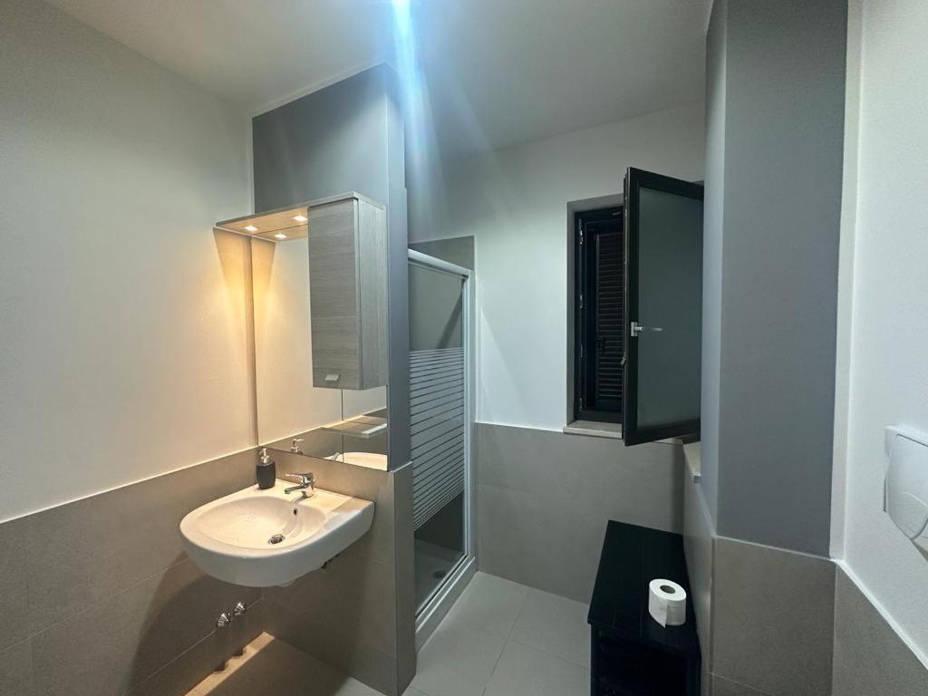 Baño blanco con lavabo y espejo en Villa swamy, en Bisceglie