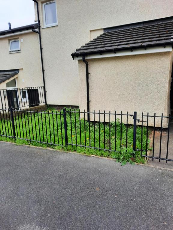 a black fence in front of a house at Lovely 2-Bed House in the heart of Woodhouse Leeds in Leeds