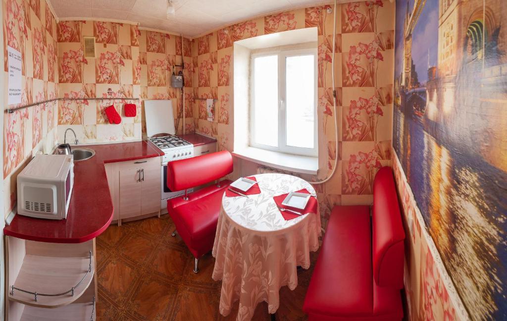 a small kitchen with red chairs and a table at Apartment Mira 35 in Kryvyi Rih