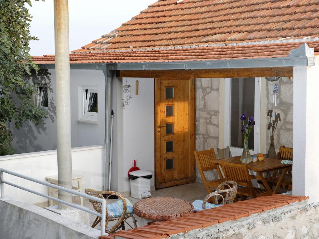 eine Terrasse mit einem Tisch und Stühlen auf einem Haus in der Unterkunft Apartment Cacini Dvori in Lastovo