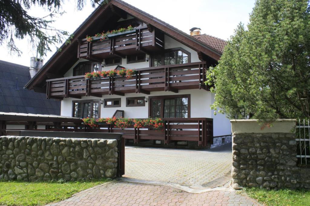 a house with wooden balconies and flowers on it at Villa Tatry Stola in Vyšné Hágy