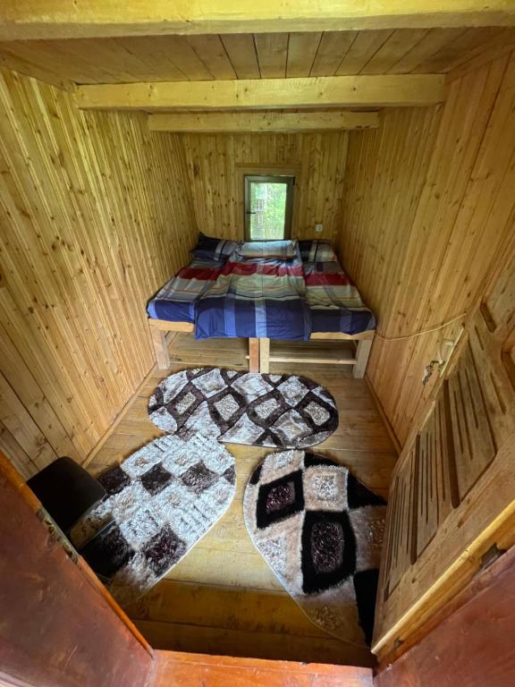Cette cabine en bois offre une vue de tête sur deux lits. dans l'établissement Cabana trei paltini, à Poiana Vadului