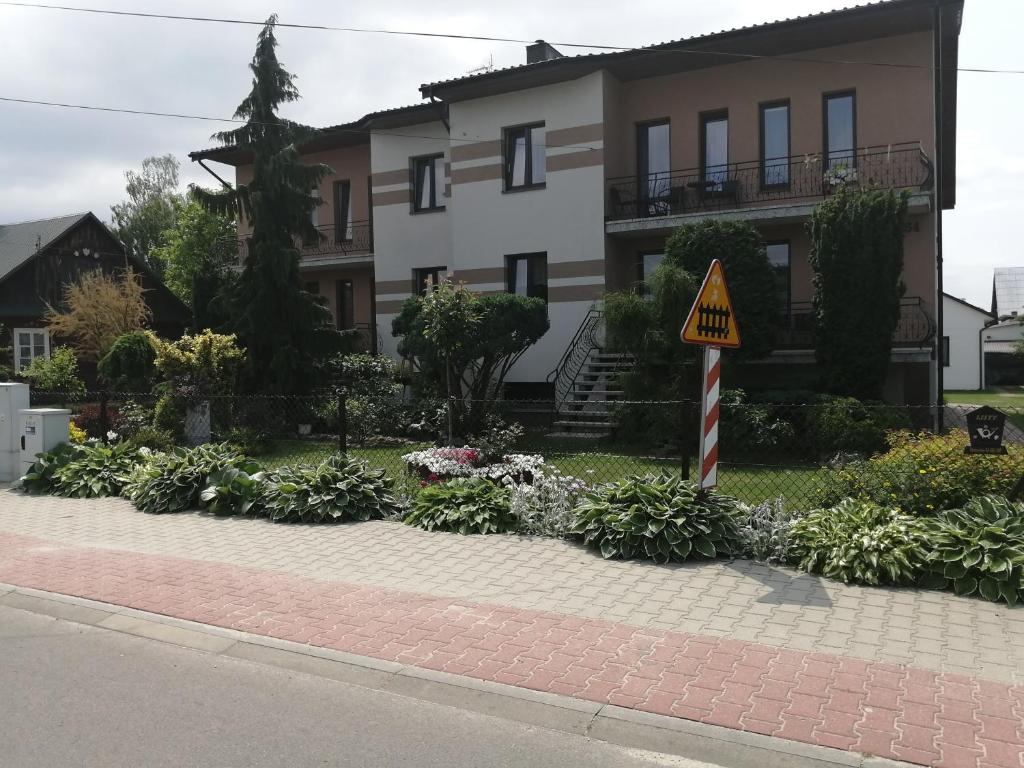 una casa con un letrero al lado de una calle en Noclegi Janina Surmacz, en Zwierzyniec