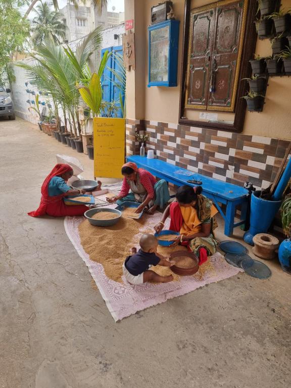 a group of people sitting on the floor eating food at Dream Vision Guest House in Diu