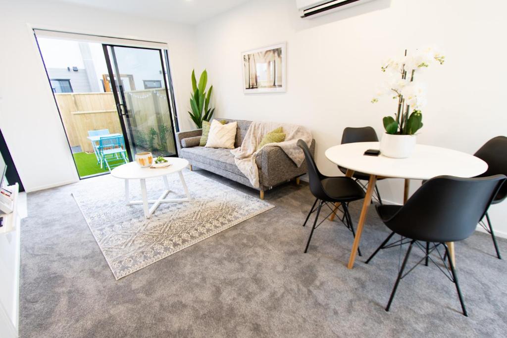 a living room with a couch and a table and chairs at Beachside Haven 1 bed 1 bath in Christchurch
