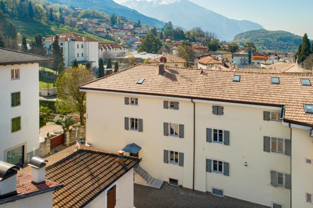 uma vista para uma cidade com edifícios e montanhas em La Canonica Suite Apartments New Location em Trento