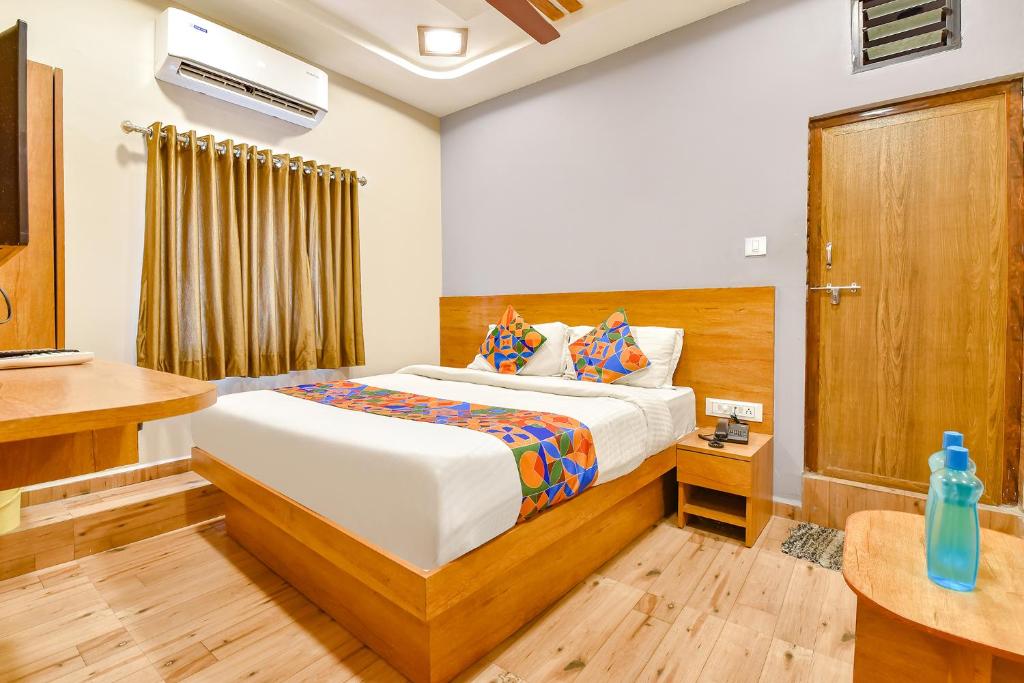a hotel room with a bed and a desk at FabExpress Gokul Villa in Ahmedabad