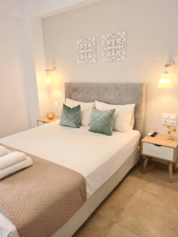 1 dormitorio con 1 cama blanca grande y 2 almohadas en Bella Mare Luxury Apartments, en Kalamaki