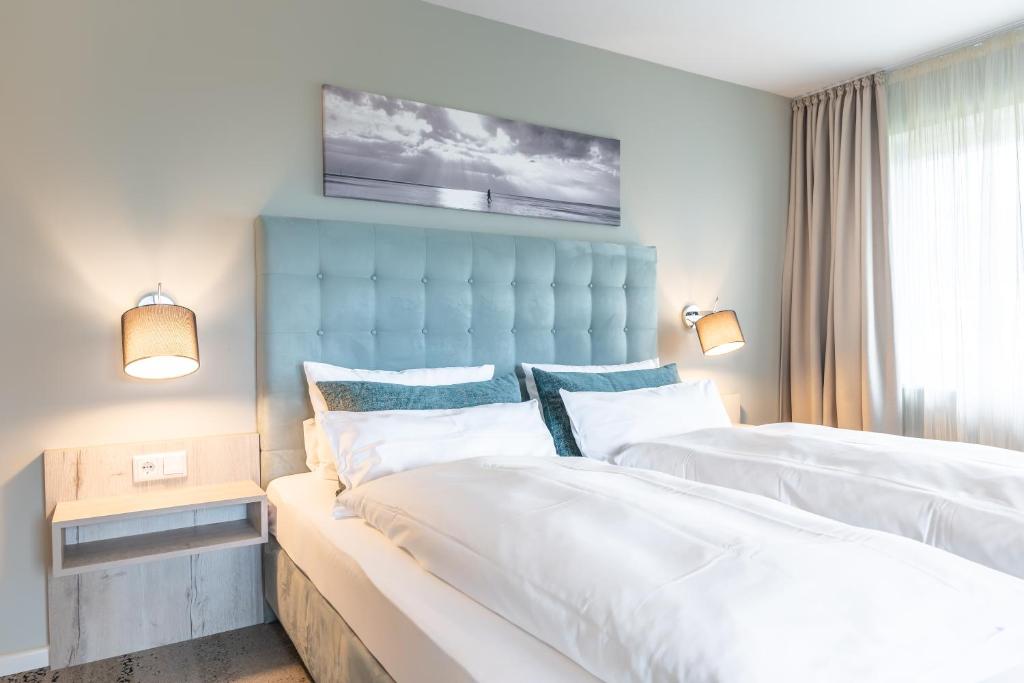 um quarto com 2 camas e uma cabeceira azul em Waastwinj - 500m vom Strand em Utersum