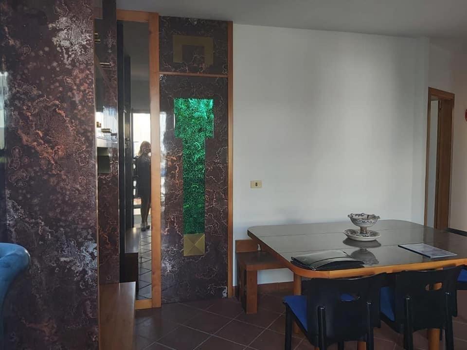 a dining room with a table and a green window at La portuense in Castro di Lecce