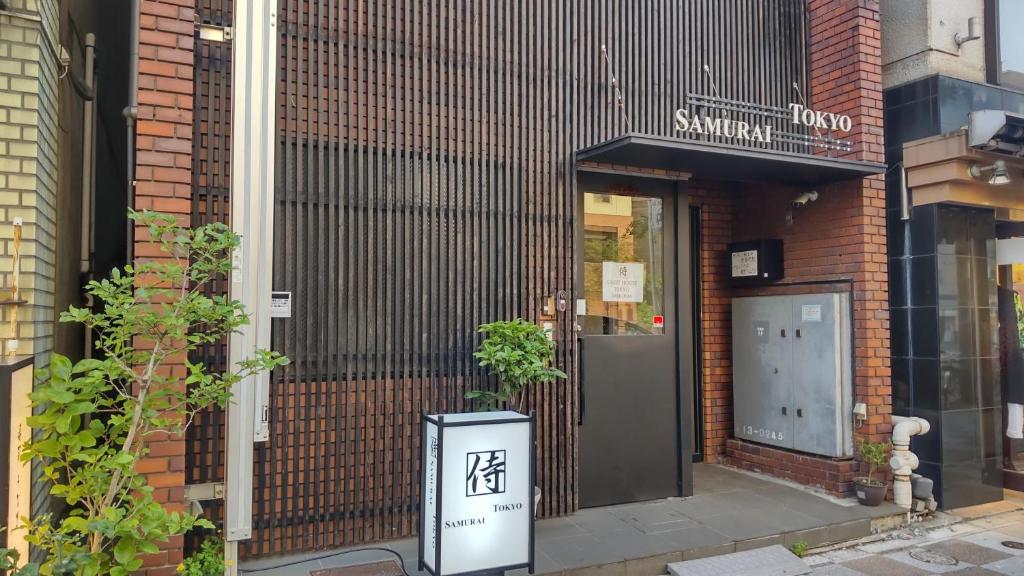 un edificio con una señal delante de una puerta en Guest House Tokyo Samurai en Tokio