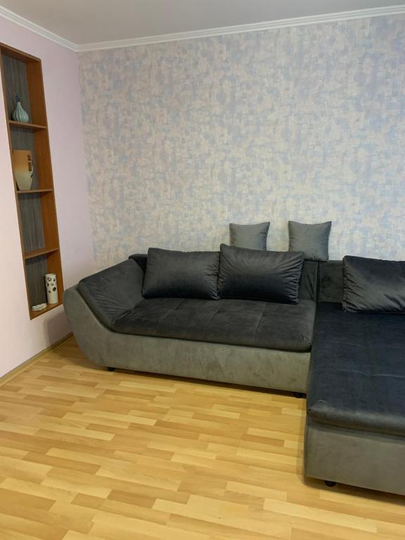 uma sala de estar com um sofá e um piso de madeira em Затишна квартира на бульварі Свободи 49 ЖОВТІ ВОДИ em Zhovti Vody