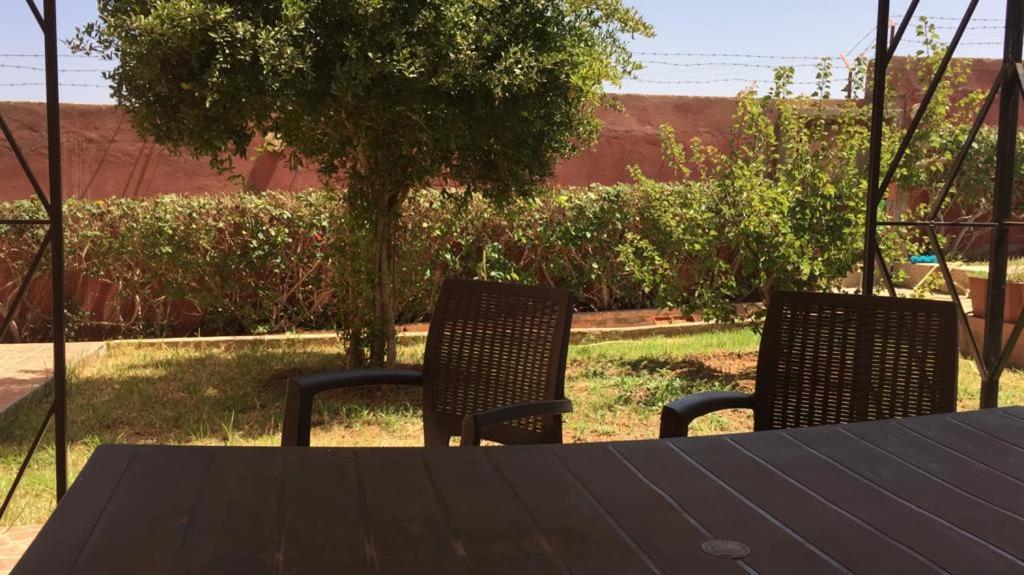 uma mesa e duas cadeiras sentadas numa mesa em Villa à la compagne em Mohammedia