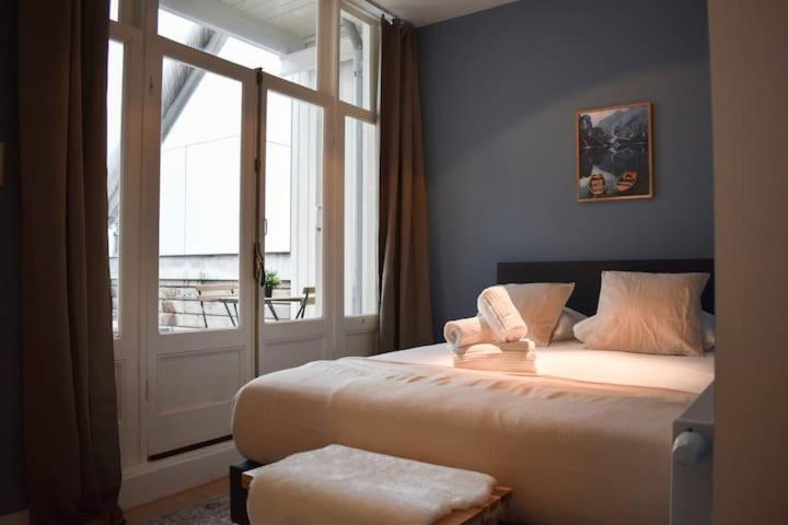 een slaapkamer met een groot bed en een groot raam bij Rembrandtplein Apartments in Amsterdam