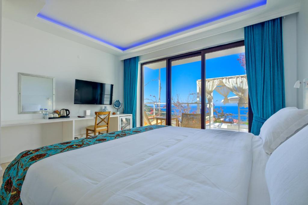 1 dormitorio con 1 cama blanca grande y ventana grande en Highclere Hotel and Spa, en Faralya