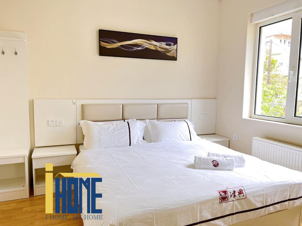 a bedroom with a large white bed with white pillows at Ammo Glyfada Residences in Athens