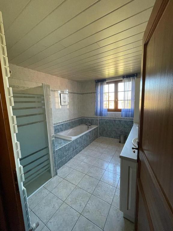 a large bathroom with a tub and a sink at le Pigeonnier gersois in Condom