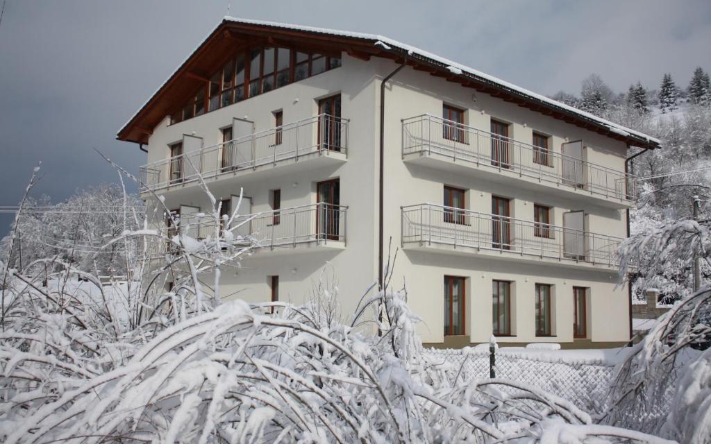 ein schneebedecktes Gebäude mit Bäumen und Sträuchern in der Unterkunft Villa Malina in Oščadnica