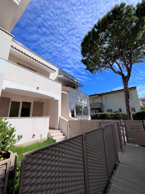 a house with a fence and a tree at Bilo Giacomo a 150 m dal mare in Marcelli