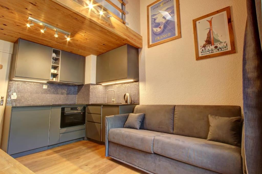 ein Wohnzimmer mit einem Sofa und einer Küche in der Unterkunft Iris Triplex studio in Chamonix-Mont-Blanc