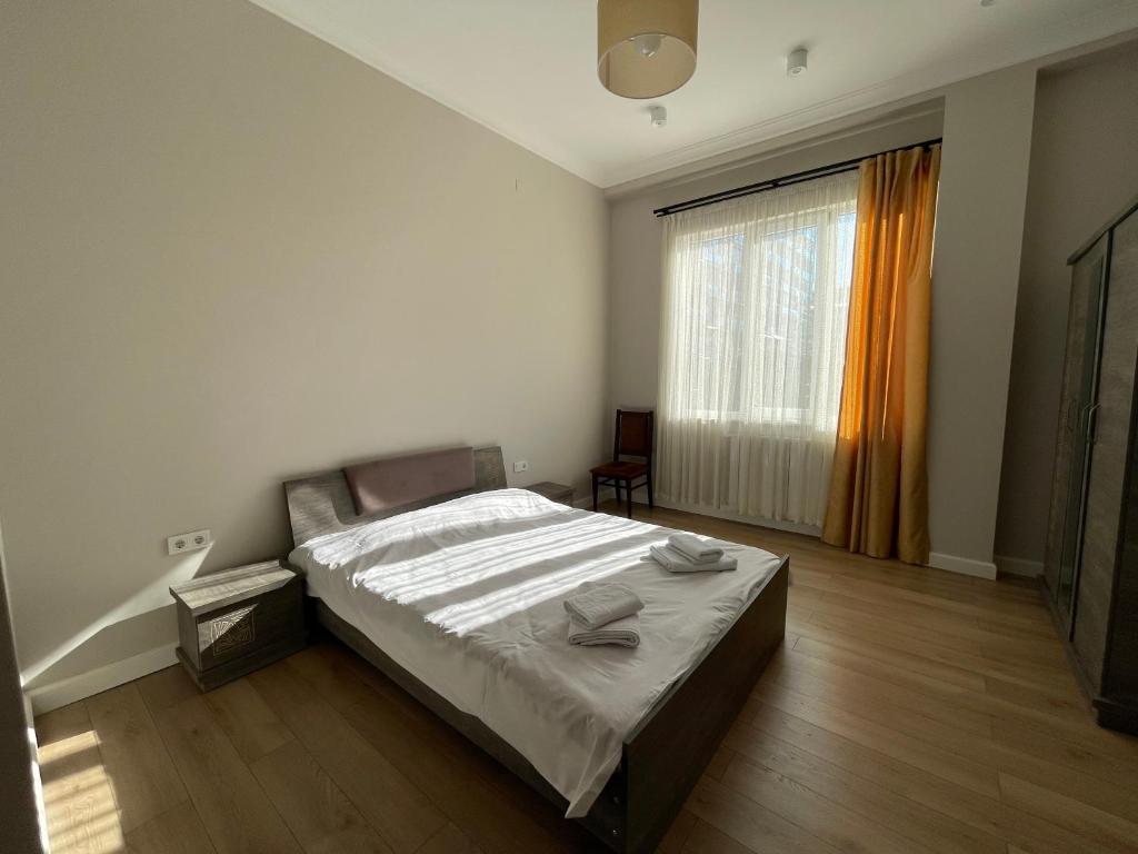 a bedroom with a bed and a large window at Shveli Apartment in Batumi