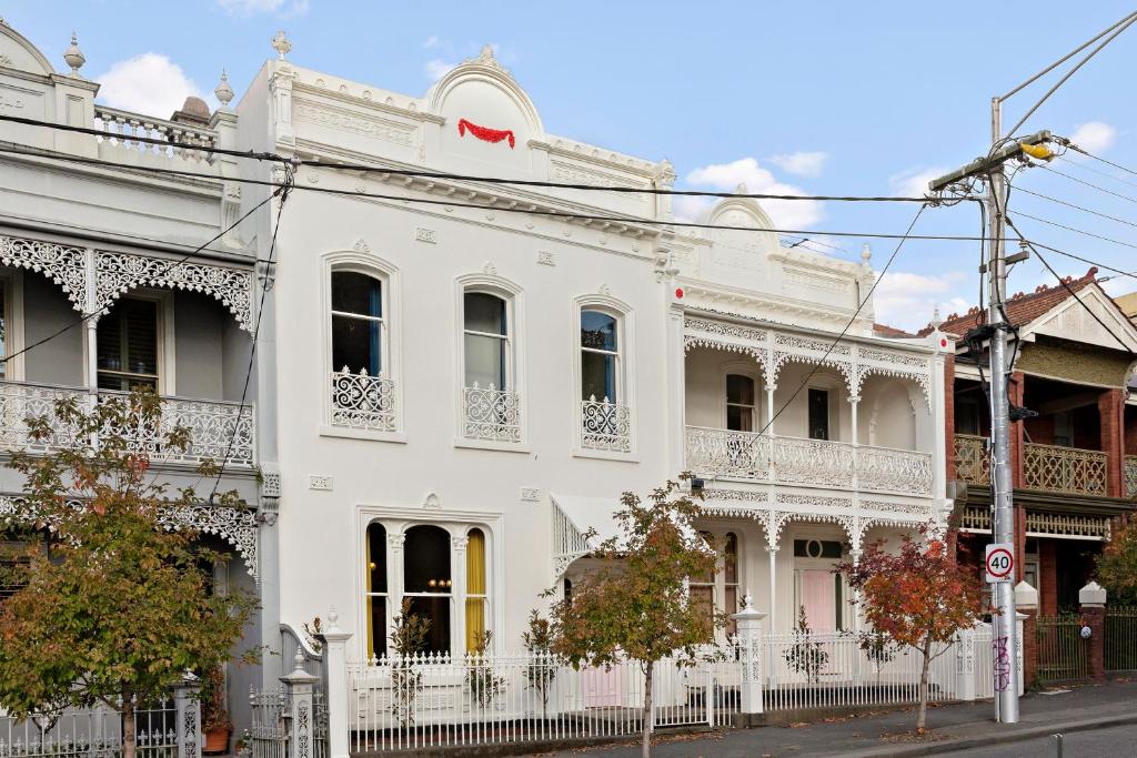 een wit gebouw op de hoek van een straat bij The White House Fitzroy - One of the largest single dwelling accommodations in Melbourne