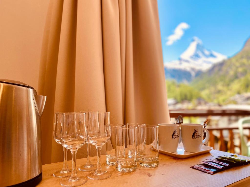 een groep wijnglazen op een tafel bij Hotel Capricorn in Zermatt