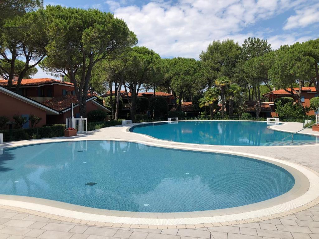 - une piscine dans un complexe avec des arbres en arrière-plan dans l'établissement Villaggio Euroresidence, à Bibione