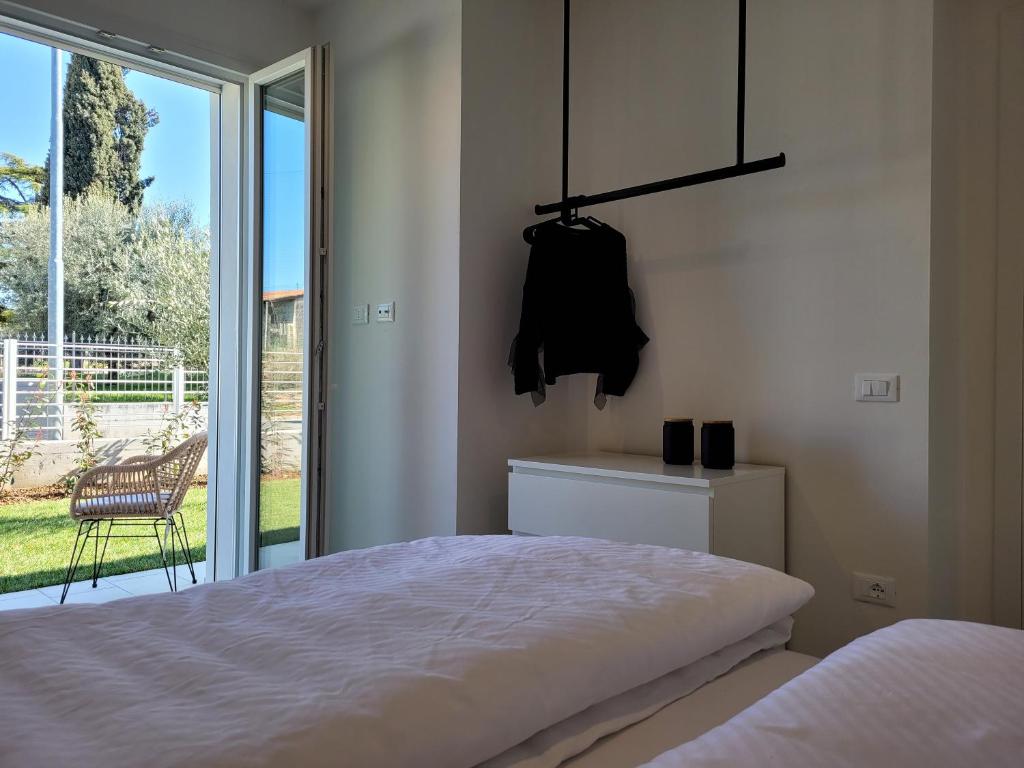 une chambre avec un lit et une porte coulissante en verre dans l'établissement Villa My Lagozise, à Pacengo di Lazise