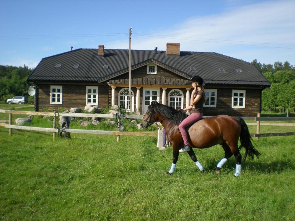 Eine Frau, die vor einem Haus reitet in der Unterkunft Senosios Geguzines ukis in Gegužinė