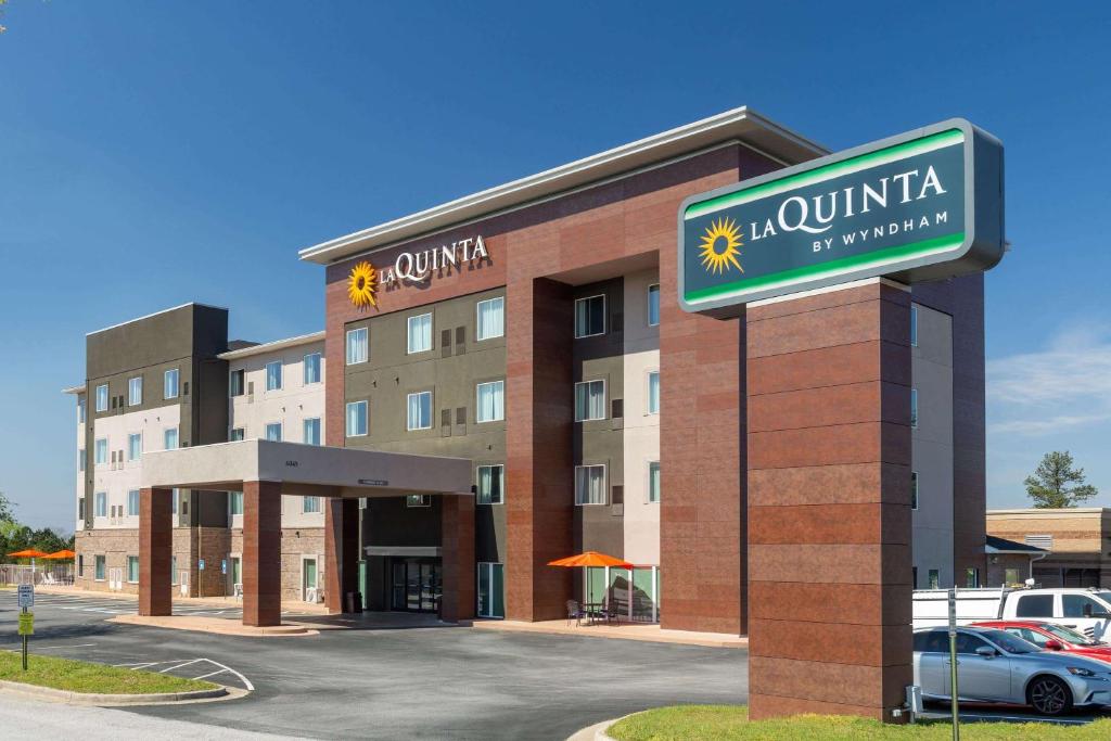 un edificio de hotel con un cartel delante en La Quinta Inn & Suites by Wyndham Augusta Fort Eisenhower, en Augusta
