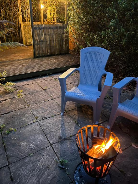 two chairs and a fire pit on a patio at night at Turning Tides Holiday Cottage in Great Yarmouth