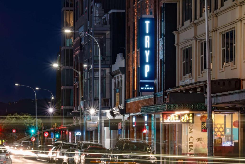 une rue animée de la ville la nuit avec des voitures et des lumières dans l'établissement TRYP by Wyndham Wellington, Tory Street, à Wellington