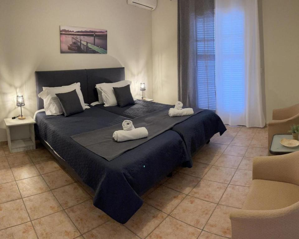a bedroom with a large bed with two towels on it at Georgia's Apartments, Ipsos - Complex S in Ýpsos