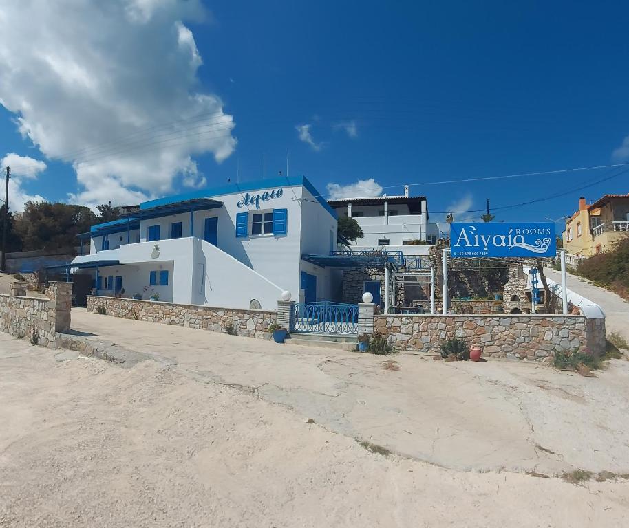un edificio azul y blanco con un cartel en él en Aigaio studios & rooms, en Azolimnos