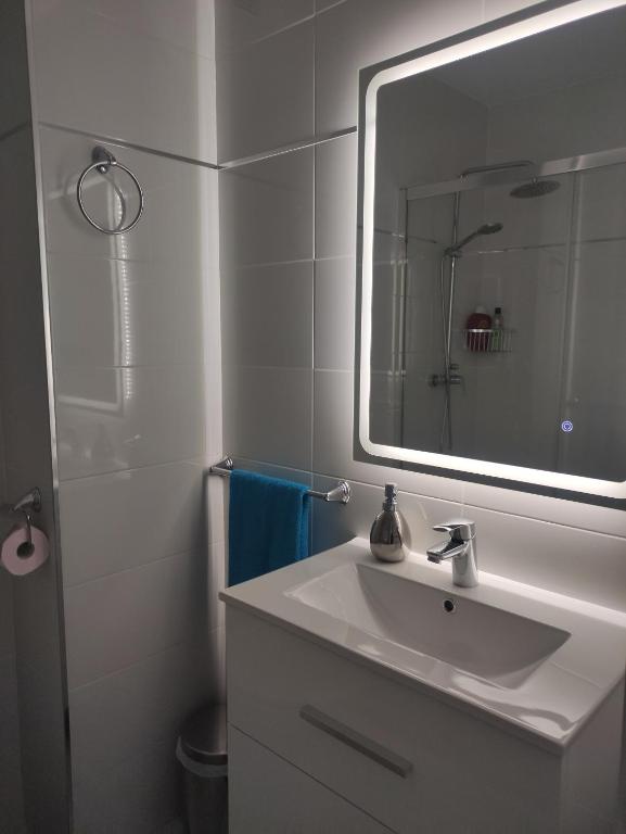 uma casa de banho branca com um lavatório e um espelho em Apartamento vacacional máximo 4 personas em Novo Sancti Petri
