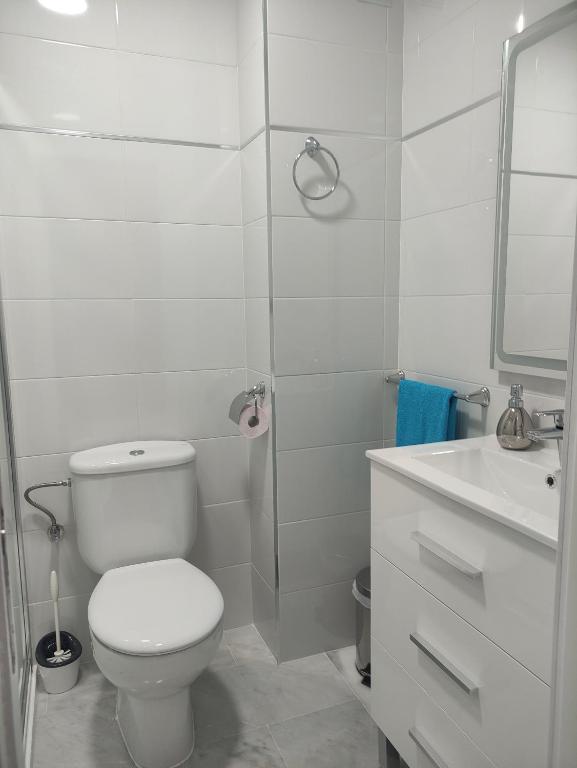 a white bathroom with a toilet and a sink at Apartamento vacacional máximo 4 personas in Novo Sancti Petri