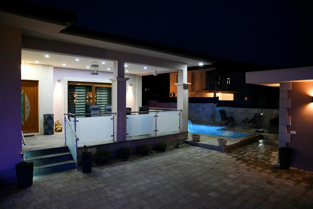 a house with a swimming pool at night at Villa Ellena in Mostar