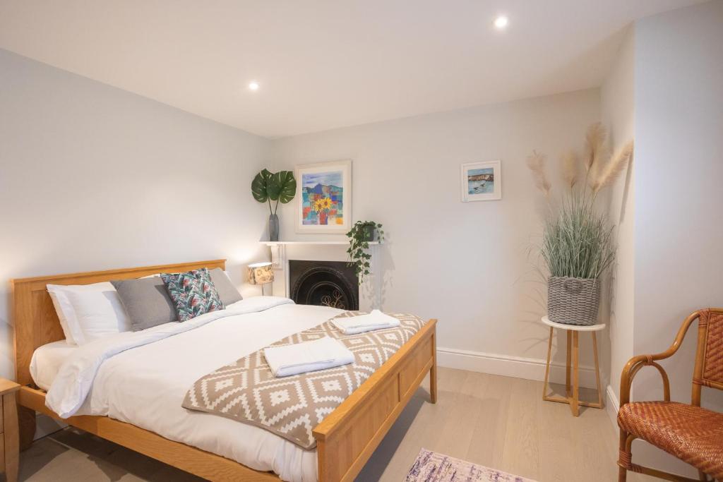 Spacious 1BR Victorian Cheltenham flat in Cotswolds Sleeps 4 - FREE Parking في تشلتنهام: غرفة نوم بسرير كبير ومدفأة