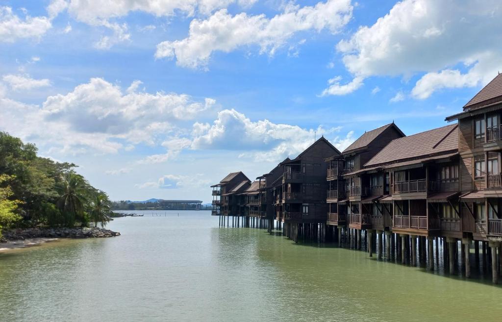 a row of houses on a river with buildings at Langkawi Lagoon Hotel Resort in Kampung Padang Masirat