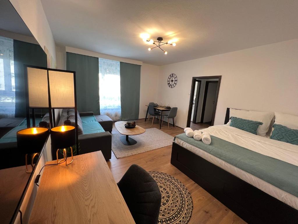 a bedroom with a bed and a living room at Friendly Space Apartment in Graz