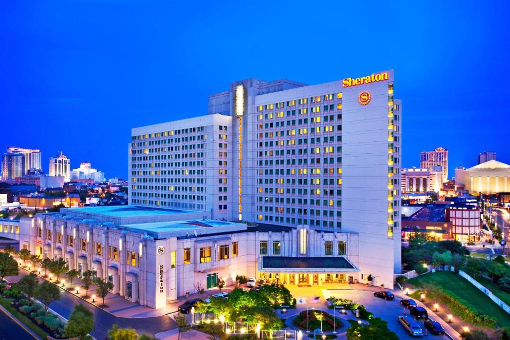 een groot wit gebouw met 's nachts een klok bij Sheraton Atlantic City Convention Center Hotel in Atlantic City