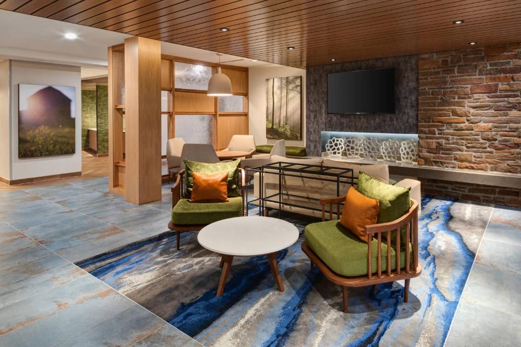 a lobby with chairs and a table and a tv at Fairfield Inn & Suites by Marriott Lexington East/I-75 in Lexington